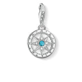Silver compass pendant with a blue gemstone on a white background
