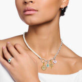 Woman wearing necklace with colorful charms on a white background