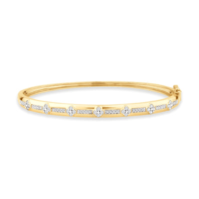 Yellow gold bangle bangle featuring alternating floral shaped diamond clusters and rows of small round diamonds set in a sleek, polished band.