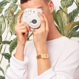 Person holding a white camera with Gold Casio Watch on the wrist