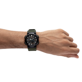 Hand wearing a black and green watch on a white background