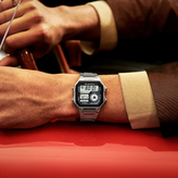 Digital casio wristwatch on a person's wrist while driving