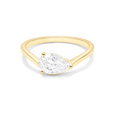 A yellow gold ring featuring a pear-cut clear gemstone in a prong setting, shown on a clean white background.