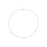 A delicate gold chain necklace with small blue and clear gemstone accents spaced along the band, displayed on a clean white background.