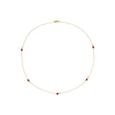A delicate gold chain necklace with five small red gemstone accents spaced evenly around the circle, displayed on a clean white background.