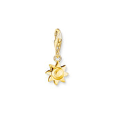 Gold sun charm on a white background