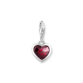Heart-shaped charm with a red gemstone on a white background