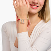Woman wearing a silver bracelet with the number '21 & 8' on a white background