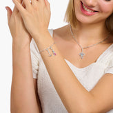 Woman wearing a silver bracelet and necklace on a white background