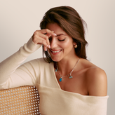 Woman wearing a necklace with a plain background