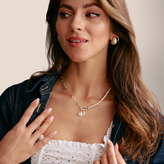 Woman wearing a necklace with a sun pendant A pendant and pearl accents.