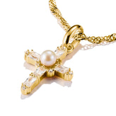 Gold cross pendant with a pearl and clear stones on a white background
