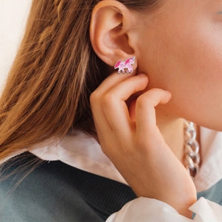 Close-up of a person wearing pink earrings with a blurred background